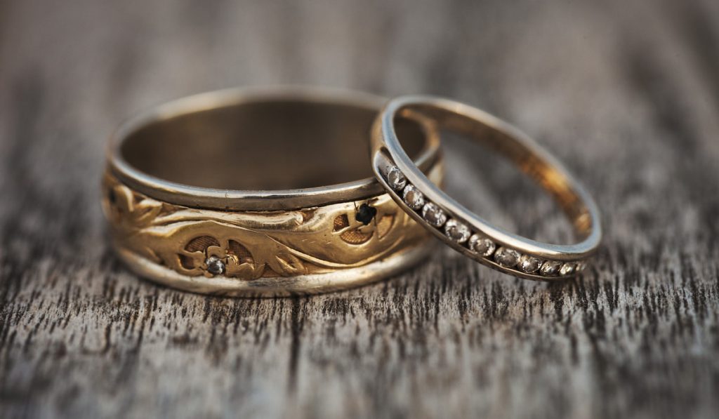 Close up of old golden wedding bands on wooden table