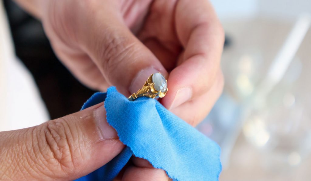 Jeweler hand polishing gold ring