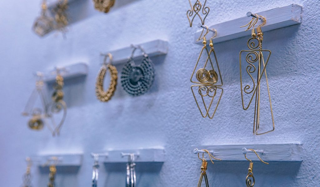 Jewelries, Brass Earrings Displayed for Sale on a White Wall