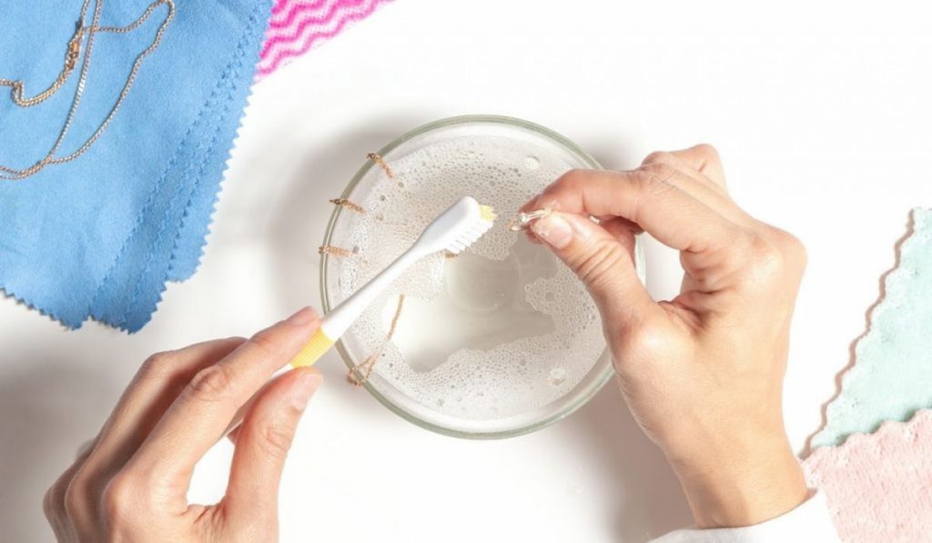 cleaning jewelry with a soap water andf toothbrush