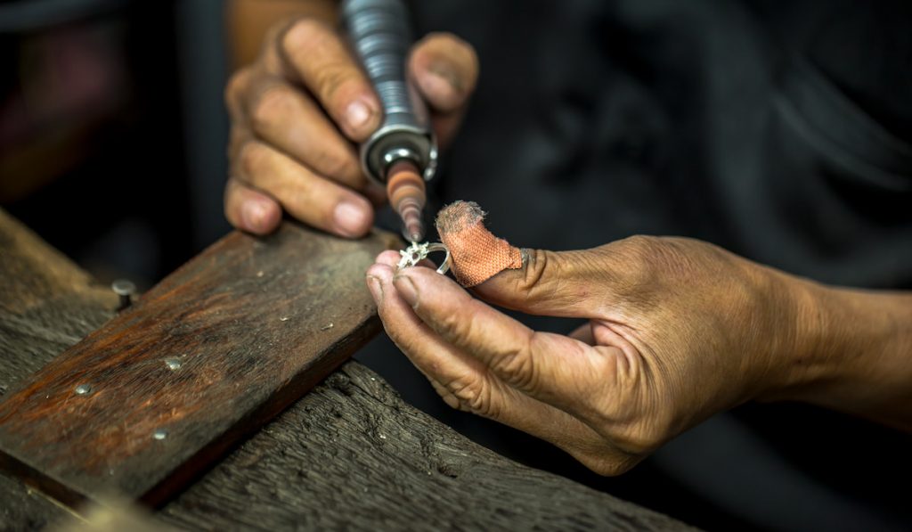 jeweler polishing inside setting of ring before putting stone