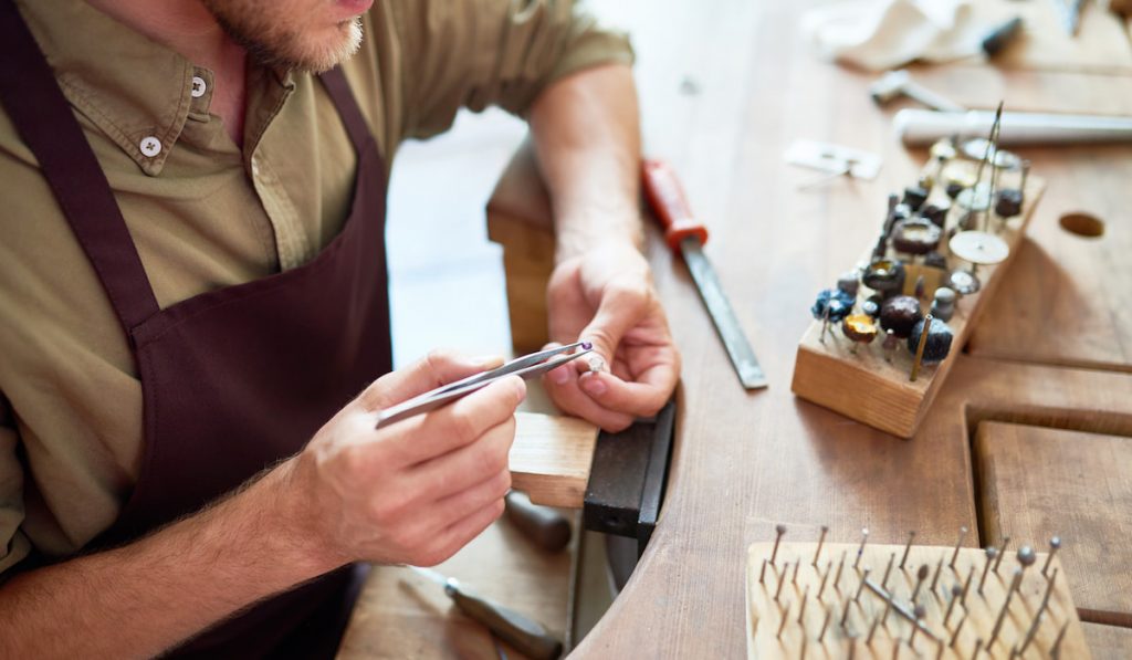 jeweler putting stone on silver ring in his workshop