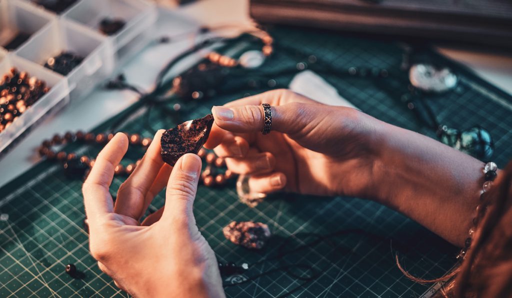 woman holding natural stone making jewelry 