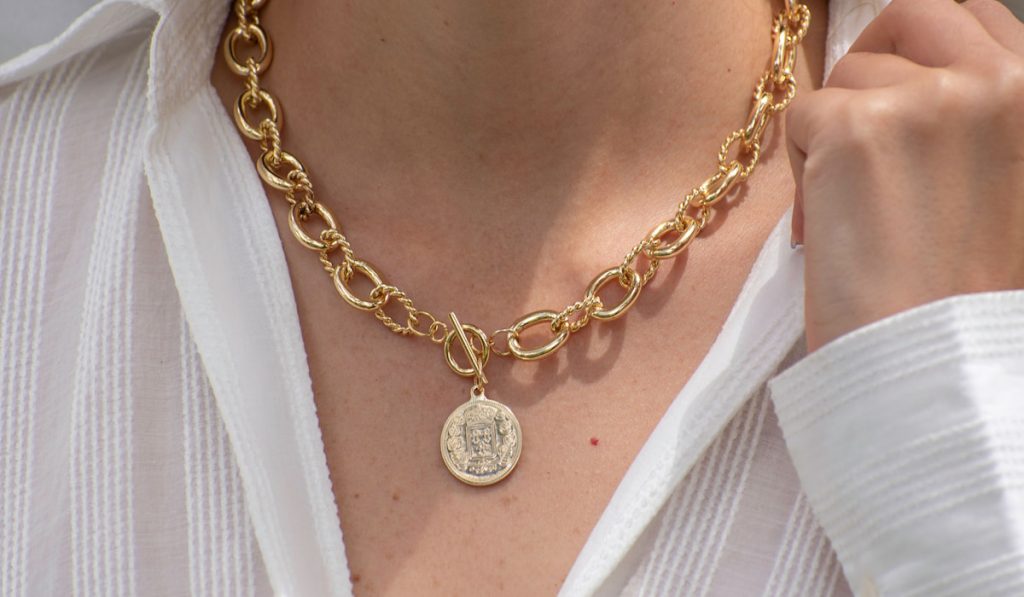 woman holding collar wearing necklace with coin pendant