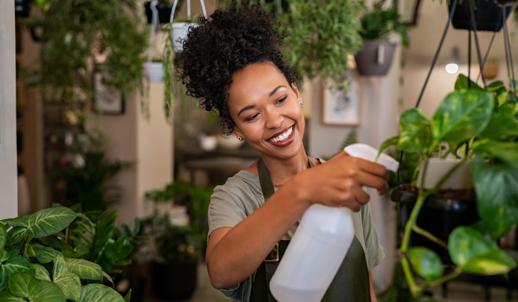 woman watering plants in botany shop
